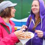 Photo by Kelly Sullivan/Peninsula Clarion Janel Elliott and Hiedi Berg share a funnel cake at the 24th annual Kenai River Festival, June 7, at Centennial Park.