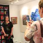 Photo by Kelly Sullivan/ Peninsula Clarion Laurie Marta takes a picture of Lynn Mettille in front of the quilt Mettille made, June 6, at the Kenai Fine Arts Center.