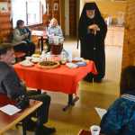 Photo by Rashah McChesney/Peninsula Clarion Sen. Peter Micciche, R-Soldotna, listens as Bishop David Mahaffey talks about the name of the Holy Assumption of the Virgin Mary's Russian Orthodox church's newly blessed outbuilding Thursday June 12 2014 in Kenai, Alaska.