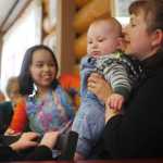 Photo by Rashah McChesney/Peninsula Clarion  Louise Coffey whispers to her son Aldric Coffey during a gathering at Fort Kenay after a blessing ceremony at the Holy Assumption of the Virgin Mary Russian Orthodox church's new outbuilding Thursday June 12, 2014 in Kenai, Alaska.