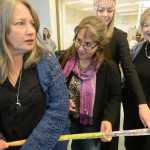Photo by Rashah McChesney/Peninsula Clarion   Maggie Jones and Sondra Shaginoff-Stuart talk about squeezing more people into the growing circle joining a cloth-tearing ceremony Thursday June 12, 2014 during the grand opening ceremony of Kenaitze Indian Tribe's Dena'ina Wellness Center in Kenai, Alaska.