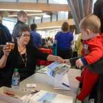 Photo by Rashah McChesney/Peninsula Clarion  Elsa Maillelle hands a jar of salmon to a visitor during the grand opening ceremony of the Kenaitze Indian Tribe's Dena'ina Wellness Center Thursday June 12, 2014 in Kenai, Alaska.