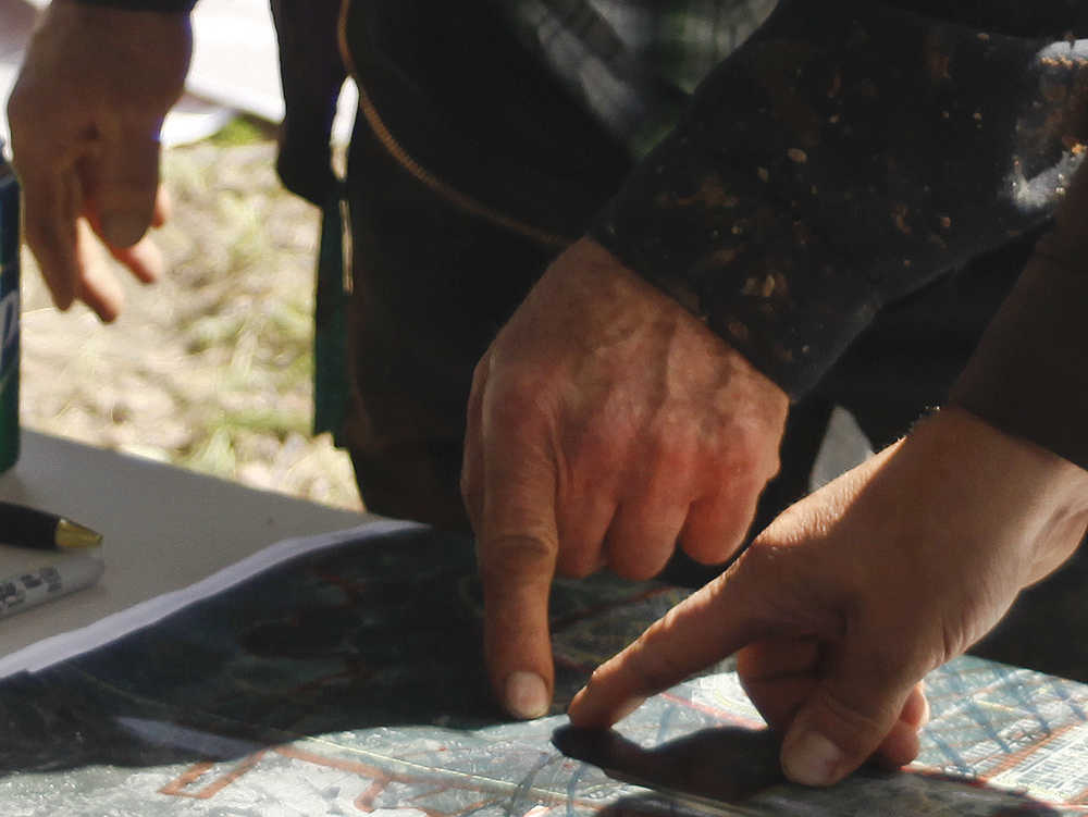 Photo by Rashah McChesney/Peninsula Clarion Volunteers discuss locations on a map where a community search has been started for a missing Kenai family Tuesday June 24, 2014 in Kenai, Alaska.