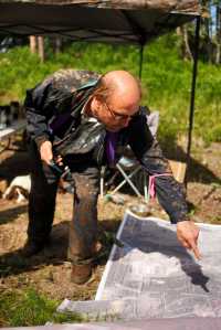 Photo by Rashah McChesney/Peninsula Clarion Matt Schilf, of Kenai, points to a spot on a large map of a portion of Kenai near the home of a missing Kenai family Tuesday June 24, 2014 in Kenai, Alaska.  Schilf and 14 others spent the bulk of the day searching in the woods for signs of the family.