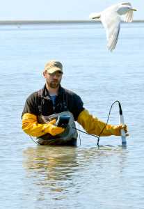 Photo by Rashah McChesney/Peninsula Clarion BBranden Bornemann, environmental scientists for the of the Kenai Watershed Forum, takes a water sample at the mouth of the Kenai River for an Alaska Department of Environmental Conservation and City of Kenai program that measures bacteria in the water in Kenai, Alaska.