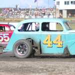 Photo by Kelly Sullivan/ Peninsula Clarion Legend car racers Tye Torkelson in car number 44, and David Kusmider in car number 55 are neck and neck during their race, Saturday, June 28, at Twin City Raceway.