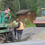 Photo by Rashah McChesney/Peninsula Clarion Tinker Anderson drives a paver Richie DiCarlo and Aarron Settje work to keep a pre-asphalt leveling material even on a new portion of a bicycle trail running along Kalifornsky Beach Road Thursday July 3, 2014 in Kenai, Alaska.