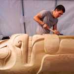 Haida carver TJ Young works on a bear holding its tongue on the Eagle totem pole for the Gajaa Hít building on Thursday. TJ and his brother, Joe, have been working on two poles and a screen to replace the aging ones in front of the building. The project has been organized through Sealaska Heritage Institute in conjunction with the Tlingit Haida Regional Housing Authority, who owns the building.