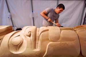 Haida carver TJ Young works on a bear holding its tongue on the Eagle totem pole for the Gajaa Hít building on Thursday. TJ and his brother, Joe, have been working on two poles and a screen to replace the aging ones in front of the building. The project has been organized through Sealaska Heritage Institute in conjunction with the Tlingit Haida Regional Housing Authority, who owns the building.
