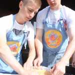 Photo by Kelly Sullivan/ Peninsula Clarion Jonas Vikstrom and Sebastian Gabriel remove their apple cake from a Dutch oven, Saturday, July 19, in Soldotna.