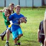 Photo by Dan Balmer/Peninsula Clarion Adam Harper, 8, carries the ball upfield during a football scrimmage Monday at Soldotna High School. Harper, known as "Beast Mode" on the field, was one of nearly 50 participants at the Kenai Peninsula Youth Football Camp, led by Soldotna High football coach Galen Brantley. The camp, open to kids through eighth grade, runs through Wednesday.