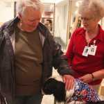 Photo by Kelly Sullivan/ Peninsula Clarion Penny Richel stops on her way up to an appointment to pet Bandit, Lynn Whitmer's certified therapy animal, Wednesday, July 23, at Central Peninsula Hospital.