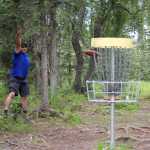 Photo by Dan Balmer/Peninsula Clarion Anchorage resident Mike Miles attempts a birdie shot during a round of disc golf July 20 at the Kenai Eagle Frisbee Golf Course. The shot clanged off the basket and MIles settled for a par.