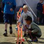 Photo by Rashah McChesney/Peninsula Clarion  (left) Gus Miller, 9, Silas Hamilton, 3, and Michael Greist Beltz, 7, play with cars during the Soldotna Progress Days festival Saturday at the Soldotna Little League Fields.
