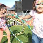 Miah Anthony, 5, of Kodiak, and her cousin Abby Samaniego, 4, of Fairbanks, play with hula hoops at Salmonstock on Friday in Ninilchik. Photo by Kaylee Osowski/Peninsula Clarion
