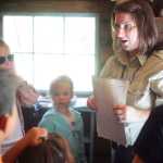 Photo by Kelly Sullivan/ Peninsula Clarion Kenai Wildlife Refuge Park Ranger Leah Eskelin talks about Andrew Berg's diaries to the group of 15 in the Family Explorer Program, Saturday, August 2, 2014, on the Keen-Eye Nature Trail in Soldotna.