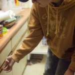 Photo by Kelly Sullivan/ Peninsula Clarion Preston Bicknell works on the dishes at mothers house, Saturday, August 9, 2014, in Soldotna, Alaska. His mother Traci Bicknell said it is a chore he is having trouble learning.