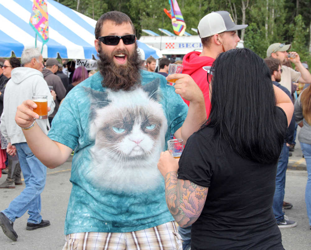 Photo by Dan Balmer/Peninsula Clarion Justin Miller from Anchorage grooves to the music while endulging in the "Hoppin' Salmon Wheat" from the Kenai River Brewing Company at the Kenai Peninsula Beer Festival in Soldotna Saturday. Twenty-two breweries from all around the state participated in the festival, which served as a fundraiser for the Rotary Club of Soldotna with benefits going to local rotary projects.