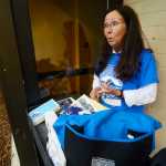 Photo by Kelly Sullivan/ Peninsula Clarion Kenai Peninsula College Advancement Programs Manager Suzie Kendrick lists the items going in the 50th anniversary time capsul at the Kenai Peninsula Borough, Kenai Peninsula College and Kenai Peninsula Borough School District joint 50th anniversary community barbecue, Thursday, August 14, at the KPC Kenai River Campus in Soldotna, Alaska.