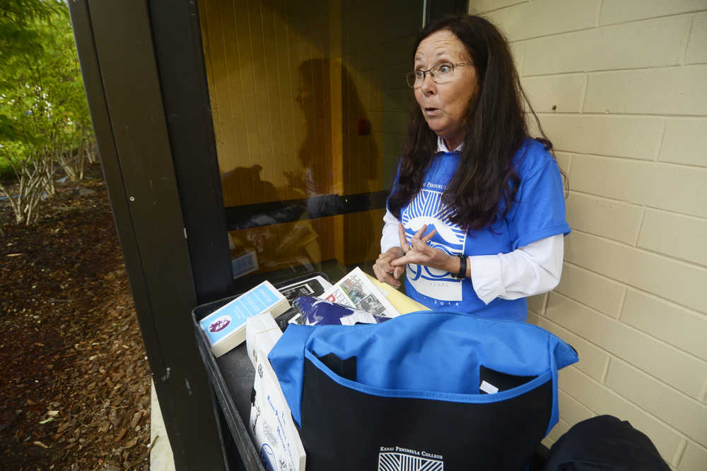 Photo by Kelly Sullivan/ Peninsula Clarion Kenai Peninsula College Advancement Programs Manager Suzie Kendrick lists the items going in the 50th anniversary time capsul at the Kenai Peninsula Borough, Kenai Peninsula College and Kenai Peninsula Borough School District joint 50th anniversary community barbecue, Thursday, August 14, at the KPC Kenai River Campus in Soldotna, Alaska.