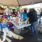 Photo by Kelly Sullivan/ Peninsula Clarion Shannette Wik creates a wild hair style for Arianna Steadman, while Brayleigh Steadman watches on at the Kenai Peninsula Borough, Kenai Peninsula College and Kenai Peninsula Borough School District joint 50th anniversary community barbecue, Thursday, August 14, at the KPC Kenai River Campus in Soldotna, Alaska.