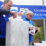 Photo by Kelly Sullivan/ Peninsula Clarion Kenai Peninsula College Direct Gary Turner places an item inside the mock-version of the 50th anniversary time capsul, which will eventually go inside the wall at KPC, during the Kenai Peninsula Borough, Kenai Peninsula College and Kenai Peninsula Borough School District joint 50th anniversary community barbecue, Thursday, August 14, at the KPC Kenai River Campus in Soldotna, Alaska.