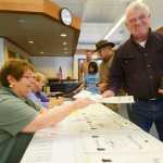Photo by Kelly Sullivan/ Peninsula Clarion Willie Porter takes his ballot from volunteer Dolores Wik, at the Nikiski Recreation Center Tuesday, August 19, 2014, in Nikiski, Alaska.