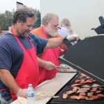Richard Thompson, left, of Kenai, a United Cook Inlet Drift Association member, grills salmon with his father, Dan Thompson, for the crowd at Industry Appreciation Day Saturday in Kenai. The event recognizes the contributions of area industries, including fishing, oil and gas, and tourism, to the community.