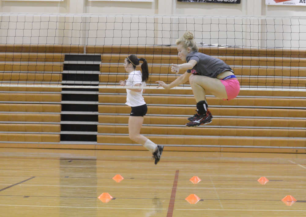 Kelly Sullivan/ Peninsula Clarion Jamie Bagley and Alli Steinbeck practice high jumps, Thursday, August 29, 2014, during the Kenai Central High School girls varsity volley ball practice, at Kenai Central High School, in Kenai, Alaska.
