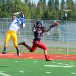 Photo by Kelly Sullivan/ Peninsula Clarion Kenai Kardinals Kylee Foree and Kodiak High School's Melvin Javier try to intercept a pass but both miss, Saturday, August 30, 2014 during the varsity game at Kenai Central High School in Kenai, Alaska.