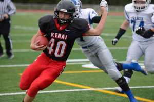 Photo by Kelly Sullivan/ Peninsula Clarion Kenai Central High School Kardinal's Number 40 Kyle Foree avoids a tackle from Palmer High School' Number 7 Kohei Watanabe or Number 7 Nathan Reeves, Friday, August 6, 2014, at Kenai Central High School in Kenai Alaska.