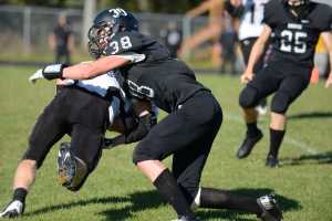 Photo by Kelly Sullivan/ Peninsula Clarion Nikiski Bulldog Dylan Brousard tackles an Eielson Raven, Saturday, September 6, 2014, at Nikiski High School in Nikiski, Alaska.