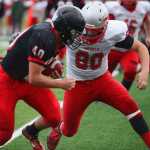 Photo by Kelly Sullivan/ Peninsula Clarion Kenai Kardinals' Kyle Foree has control of the ball as Wasilla Warriors' Austin Sodorff goes in for a tackle, Friday, September 12, 2014 at Kenai Central High School in Kenai, Alaska.