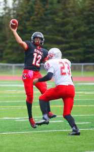 Photo by Kelly Sullivan/ Peninsula Clarion Kenai Kardinals' Jace Baker makes a quick pass before Wasilla Warriors' DJ Morrow can tackel the ball from him, Friday, September 12, 2014 at Kenai Central High School in Kenai, Alaska.