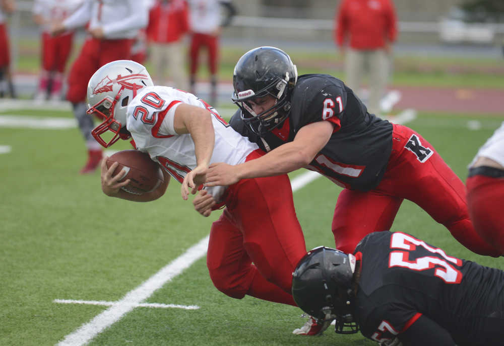 Photo by Kelly Sullivan/ Peninsula Clarion Kenai Kardinals' Kyle Hunter tackeles Wasilla Warriors' Devin Otto, Friday, September 12, 2014 at Kenai Central High School in Kenai, Alaska.