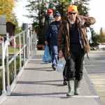 Photo by Rashah McChesney/Peninsula Clarion (left) Viktor Zoloutkhin, of Kamchatka, Margarita Panchenko, of Kamchatka,  and Maksim Ageev, of Sakhalin, head down the dock at The Pillars boat launch September 11, 2014 in Soldotna, Alaska. The group was headed on a guided coho salmon fishing trip with Fishology Alaska.