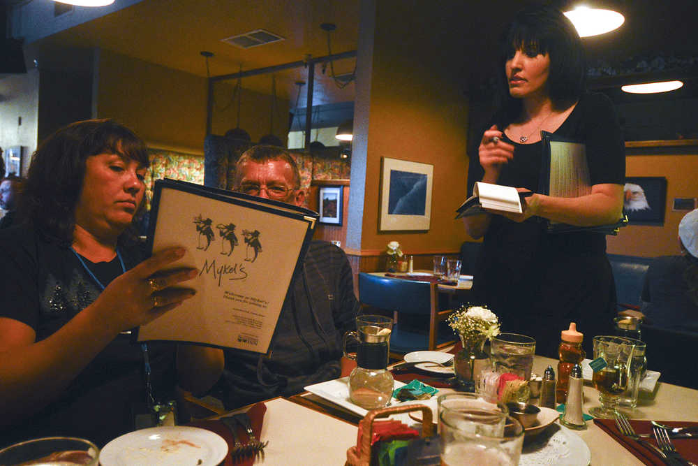 Photo by Rashah McChesney/Peninsula Clarion Margarita Panchenko, of Kamchatka, helpsViktor Zoloutkhin, of Kamchatka, order during dinner at Mykels Wednesday Sept. 10, 2014 in Soldotna, Alaska.