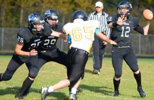 Photo by Kelly Sullivan/ Peninsula Clarion Nikiski Bulldog's Dennis Anderson makes a pass before Voznesenka Cougar's David Kuzmin can intercept, Saturday, September 20, 2014, at Nikiski High School in Nikiski, Alaska.
