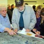 Photo by Dan Balmer/Peninsula Clarion Nikiski residents Jim and Nedra Evenson, victims of a burglary of their property, place a pin on a map that shows how many people in the community have been affected by theft. Hundreds of people attended a town hall meeting Wednesday at the Nikiski Recreation Center.