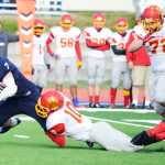 Photo by Kelly Sullivan/ Peninsula Clarion Soldotna Stars' Ty Fenton leaps to gain more yards as Faribanks' West Valley Wolf Pack's Marquece McCrae tackles him, Saturday, September 27, 2014 at Soldotna High School in Soldotna, Alaska.