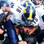 Photo by Kelly Sullivan/ Peninsula Clarion The Kenai Kardinals' take down Homer Mariner's Eric Hill, Saturday, September 27, 2014, at Kenai Central High School in Kenai, Alaska.