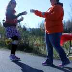 Britney Loveland, a Kenai River Marathon volunteer, offers a drink to half marathon runner Gerri Tokar-Hines, of Wasilla, on Sunday in Kenai. Photo by Kaylee Osowski/Peninsula Clarion