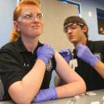 Photo by Kelly Sullivan/ Peninsula Clarion Lindey Pabst looks away as classmate Brooks Simmons practices an intramuscular injection on her, Monday, September 29, 2014, at the Kenai Peninsula College in Soldotna, Alaska.