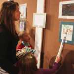 Photo by Kelly Sullivan/ Peninsula Clarion Ethan Ellis, Abena Ellis and Elisa Ellis look at Ethan Ellis's drawing that made on display at the Voices of the Wilderness travelling art show at the Kenai Visitors and Cultural Center that is part of the Kenai Wildlife Refuge's yearlong celebration of the 50th Anniversary of the Wilderness Act, Friday, October 3, 2014, at the Kenai Visitor and Cultural Center in Kenai, Alaska.