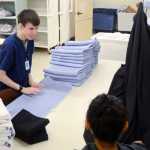 Photo by Rashah McChesney/Peninsula Clarion  Christopher Pretrovich, an intern with Project SEARCH, chats with Loren Harper and Angeline Harman as the three fold laundry Thursday October 9, 2014 at Central Peninsula Hospital in Soldotna, Alaska.