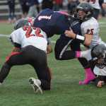 From left, Kenai's Case Gillies, Chase Logan (25) and Kyle Hunter combin for a tackle on North Pole's De' Aundre Campbell.  Photo for the Clarion by Michael Dinneen