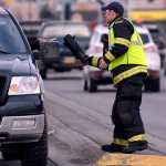 Photo by Rashah McChesney/Peninsula Clarion Kenai firefighter Dustin Voss takes money from a woman at a traffic light Friday October 17, 2014 in Kenai, Alaska. Several off-duty firefighters held a fill-the-boot campaign to raise money for the Muscular Dystrophy Association.