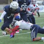 SoHi's Ty Fenton (7) is wrapped up by North Pole's Curtis McNeal.  Photo for the Clarion by Michael Dinneen