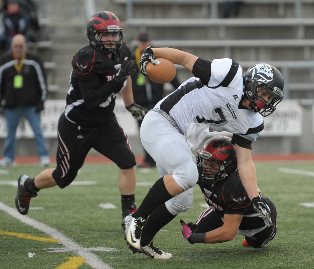 Nikiski's Christian Riddall (7) runs through a pair of Eielson defenders.  Photo for the Clarion by Michael Dinneen