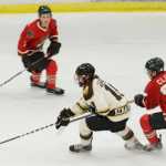 Photo by Kelly Sullivan/ Peninsula Clarion Kenai River Brown Bears' Christopher Usov beats Minnesota Wilderness' Tyler Cline for the puck Friday, October 24, 2014 at the Soldotna Regional Sports Complex in Soldotna, Alaska.